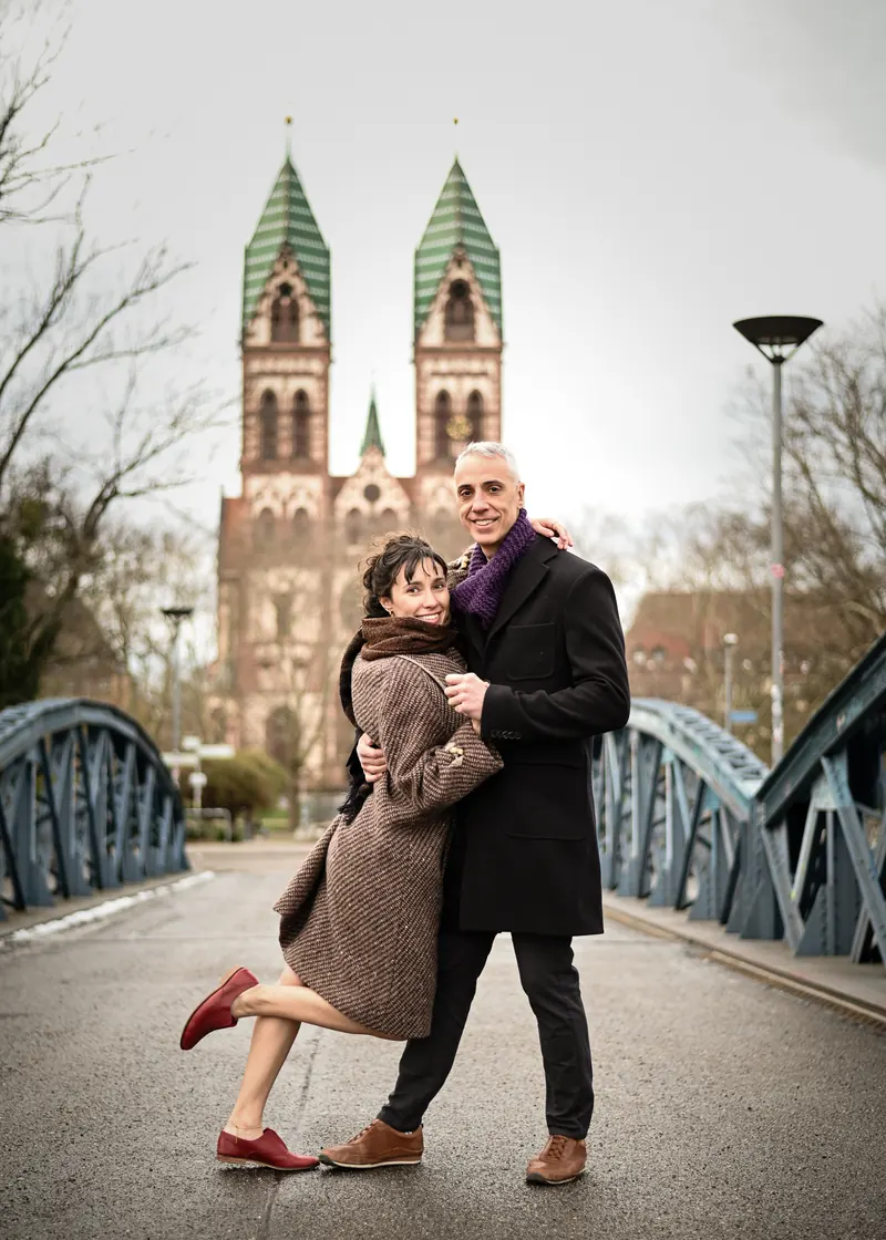Ein Paar tanzt Swing auf der Blauen Brücke in Freiburg, im Hintergrund die Herz-Jesu-Kirche