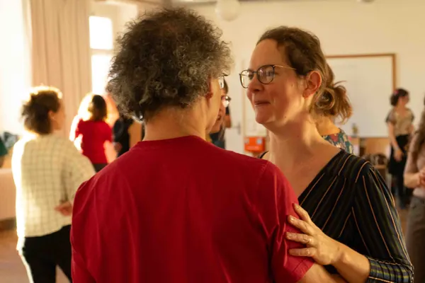 Blue Forest 2023: Eine Frau mit Brille lächelt ihren lockigen Tanzpartner während eines Workshops an