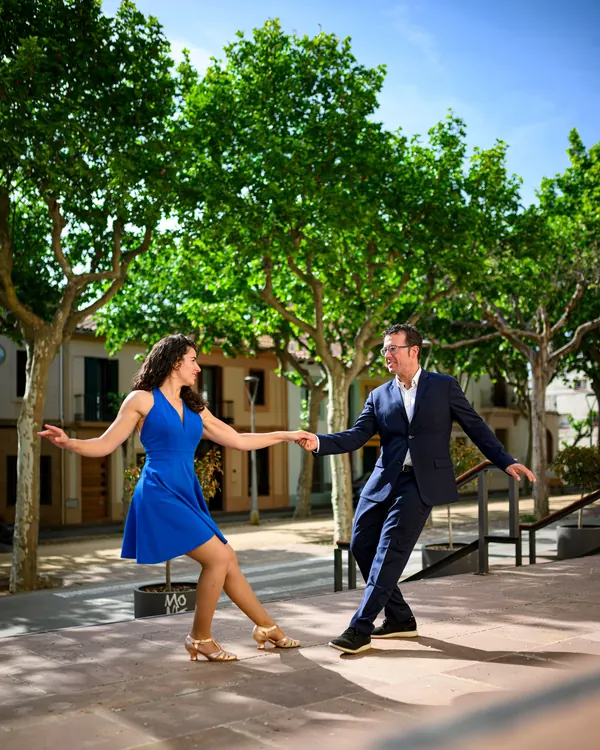 Die Lehrer Melanie & Albert tanzen Hand in Hand Swing auf einem sonnigen Platz